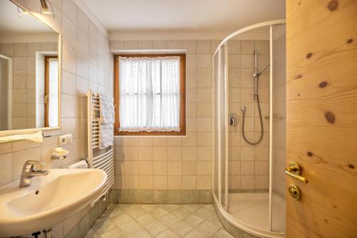 a bathroom with a shower and a sink and a tub at Ciasa Tlara App Lisa in San Vigilio Di Marebbe