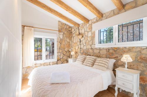 una camera da letto con un letto bianco e due finestre di Casa Rural Reme a Navarrés