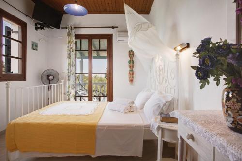 a bedroom with a bed and a vase of flowers at Areti Orfeas Studio in Vasilikos