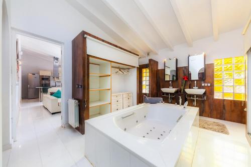 a large bathroom with a large tub and a sink at Casa Varna in Capdepera