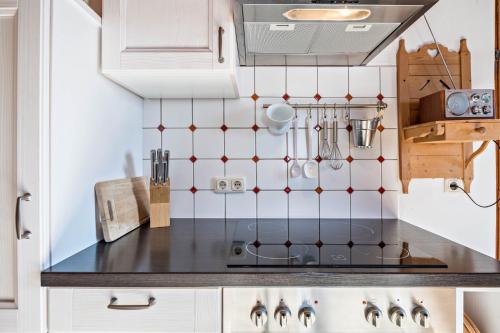 a kitchen with white cabinets and a stove top oven at Ferienwohnung Wachsbichl in Unterammergau