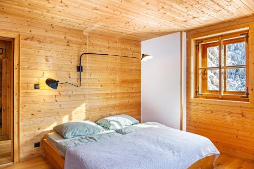 a bedroom with a wooden wall with a bed at Chalet Flocke Sternschnuppe in Sankt Anton am Arlberg