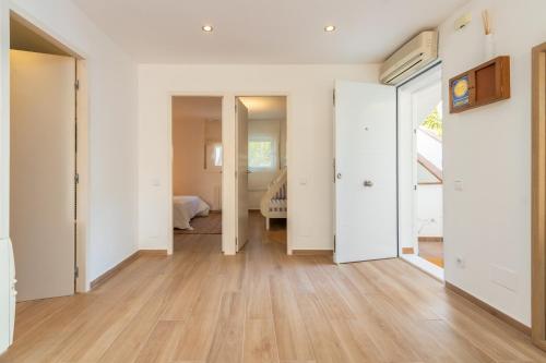 an empty room with white walls and wooden floors at Brava Beach in Platja d'Aro