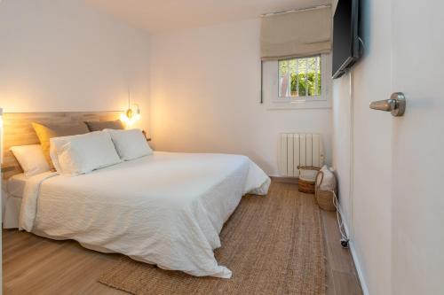 a bedroom with a white bed and a window at Brava Beach in Platja d'Aro