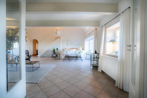a living room with a staircase and a table at Landhaus Sommerland in Uelvesbüll