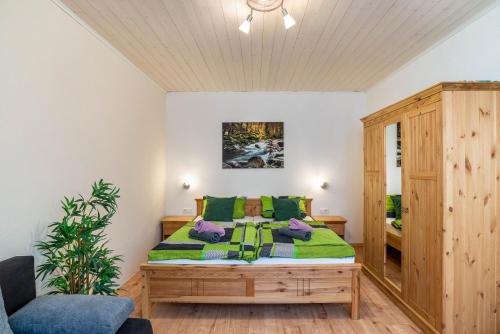 a bedroom with a bed with green pillows at Am Sersbach in Forbach