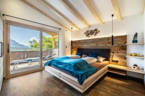 a bedroom with a large bed and a large window at Apfel Chalet Feldhof in Caines