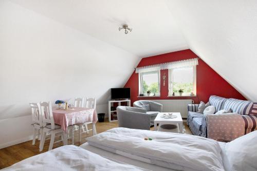 a attic room with a bed and a table and chairs at Ferienwohnung Erichsen, Viöl in Viöl