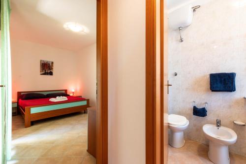 a bathroom with a bedroom with a bed and a toilet at Appartamenti Cavour Codice E in Villasimius