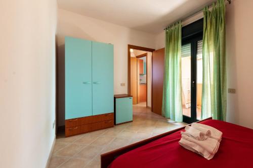 a bedroom with a red bed and a glass cabinet at Appartamenti Cavour Codice E in Villasimius