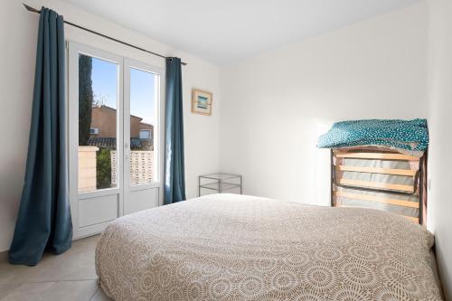 a bedroom with a bed and a sliding glass door at Maison Saint-Raphael - Les Vignes in Saint-Raphaël