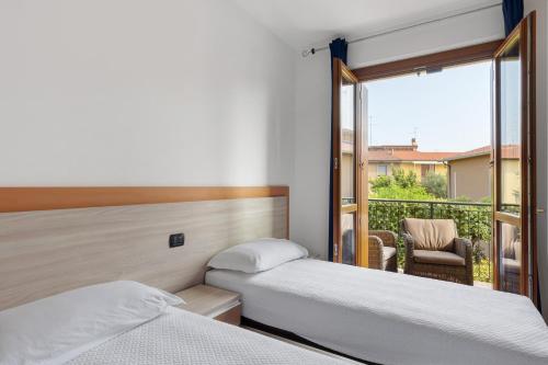 two beds in a room with a balcony at Casa Vacanze da Ricky App 5 in Peschiera del Garda