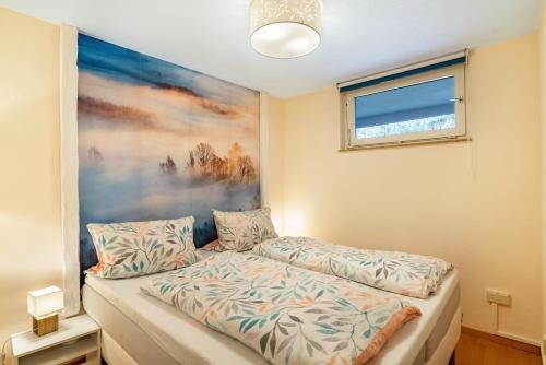 a bedroom with a bed and a painting on the wall at Schwarzwald Wölkchen in Baiersbronn