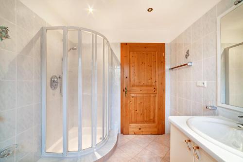 a bathroom with a shower and a tub and a sink at Rieglhof Apartment Maisel in Curon Venosta