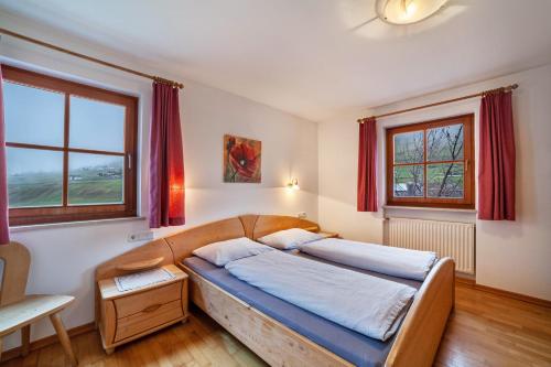 a bedroom with a large bed with red curtains at Rieglhof Apartment Maisel in Curon Venosta