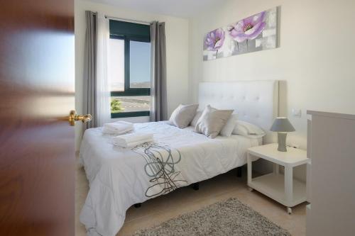 a bedroom with a white bed and a window at Duplex vista mar in Yaiza