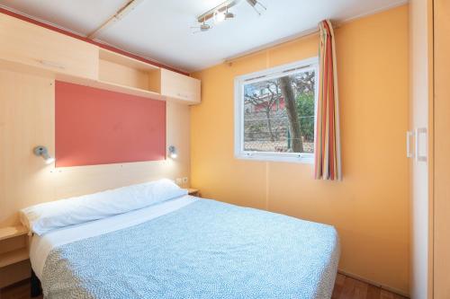 a bedroom with a bed and a window at Falaguera Bungalow 3 in Bárig