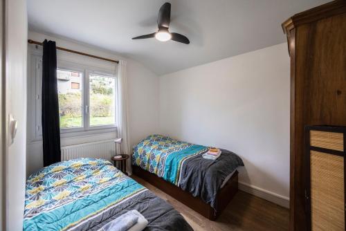 una camera da letto con due letti e una finestra di Chalet Les Tourelles ad Aix-les-Bains