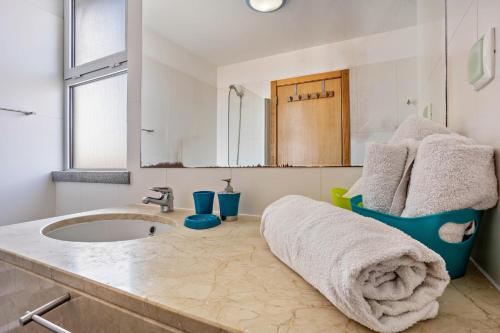a bathroom with a sink and a mirror at Sonho Dourado Apartamento de praia in Porto Santo