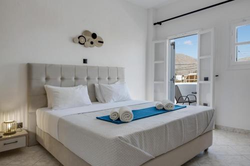 a white bedroom with a bed with towels on it at Seaview Double Room Private Jacuzzi in Santorini