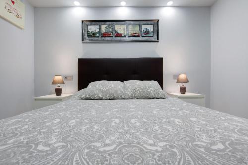 a bedroom with a large bed with two lamps at Apartamento 7 dioses in Puerto del Rosario
