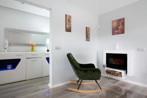 a green chair in a living room with a fireplace at Apartamento 7 dioses in Puerto del Rosario