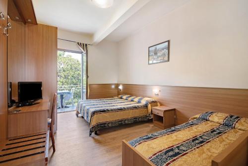 a hotel room with two beds and a television at Appartamento Bilocale Moneglia 32 in Moneglia