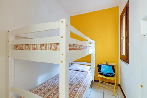 a bedroom with two bunk beds and a yellow wall at Villa del Maestro in Narbolia