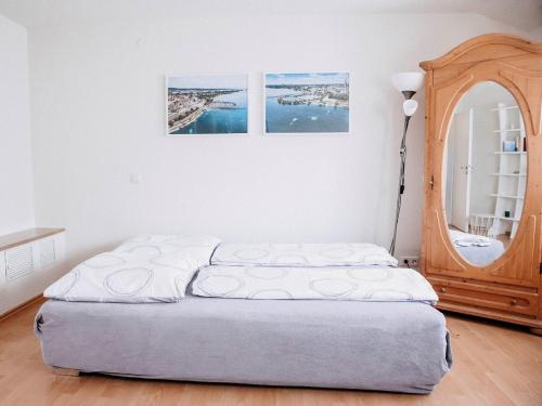 a bed in a room with two pictures on the wall at Auszeit am See in Moos