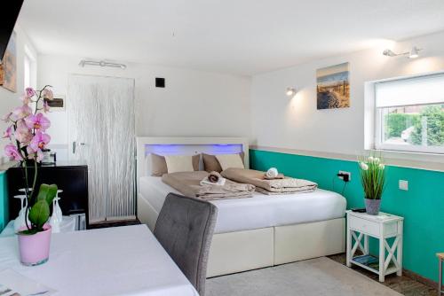 a bedroom with a bed and a table in a room at Spawo mit Sauna und Whirpool in Pfullendorf