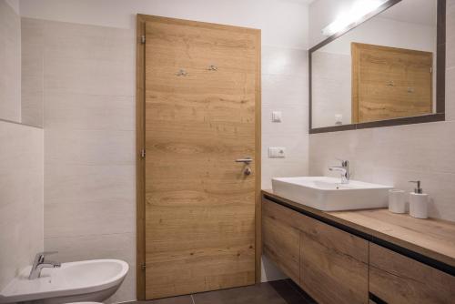 a bathroom with a toilet and a sink and a mirror at Lechnerhof Murmeltier in Valles