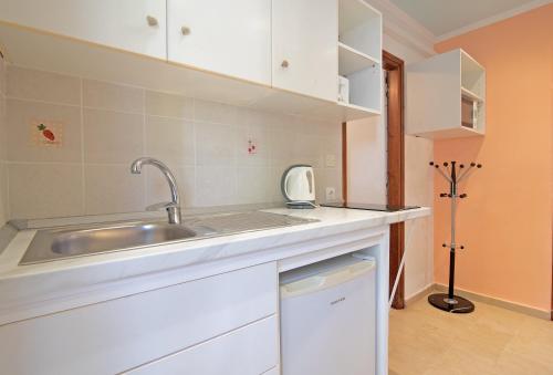 a kitchen with a sink and white cabinets at Andromaches sea view studio 2 in Corfu