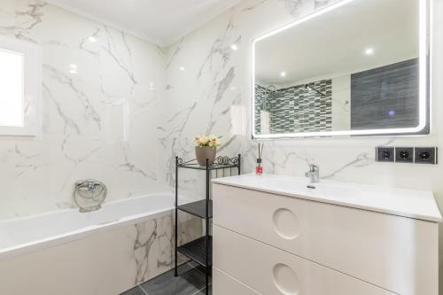 a white bathroom with a tub and a sink at Villa Sol y Mar in Calpe
