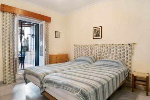 a bedroom with a bed with a striped blanket at El Mirlito in Roche