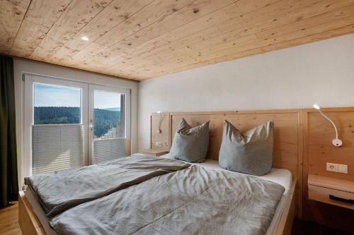 a bedroom with a bed with a large window at Ferienhaus Fenzl in Johanngeorgenstadt