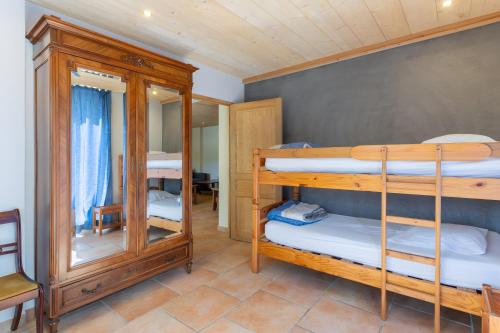 a room with two bunk beds and a mirror at Le Serre Du Puech in Chambonas