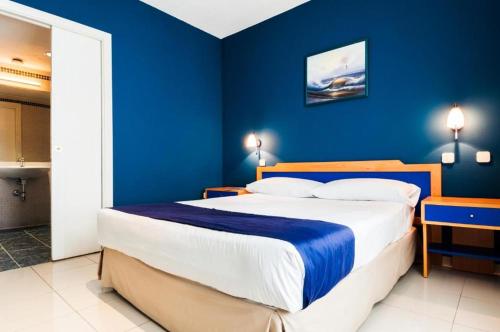 a bedroom with a large bed with blue walls at Villa De Pinto in Pinto
