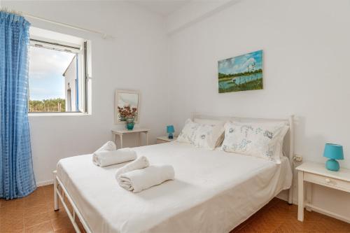 a bedroom with a white bed with towels on it at Margaret House in Parikia