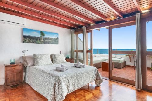 a bedroom with a bed and a view of the ocean at Casa Roque in Haría