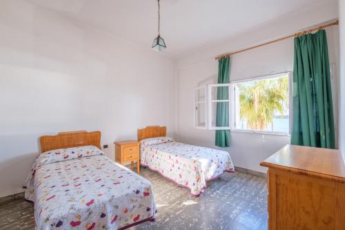 a bedroom with two beds and a window at Apartamento las Palmeras 2 in Benicarló