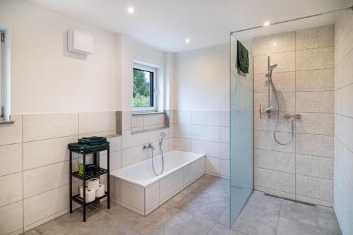 a bathroom with a shower and a tub and a sink at Kiefer in Ravensburg