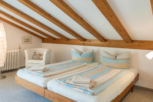 a large bed in a room with wooden ceilings at Ferienwohnung Säntisblick in Daisendorf
