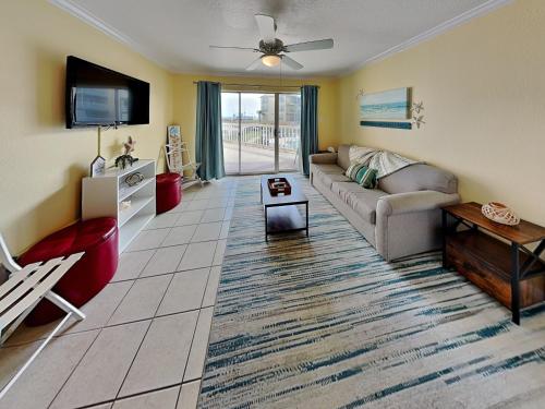 a living room with a couch and a tv at Victorian 6106 - Seaside Suite in Galveston