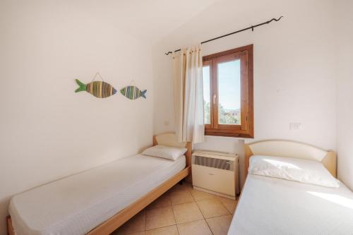 two beds in a room with a window at Casa Vacanze Pistacchio in Murta Maria