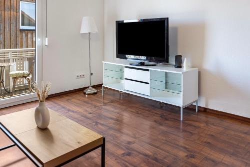 a living room with a television on a white dresser at Ülger in Pfullendorf