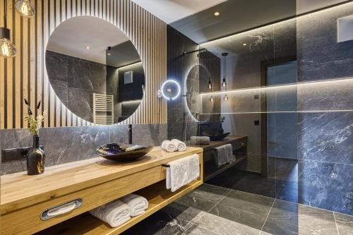 a bathroom with a sink and a mirror at Chalet Schlossberg Rosengarten in Nova Ponente