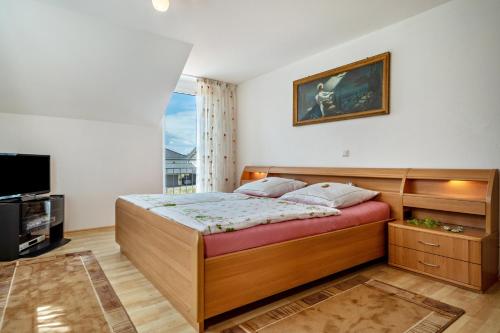 a bedroom with a bed and a television in it at Storchennest in Markdorf