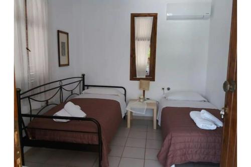 two beds in a room with a mirror at Maria's house 2 in Ilia