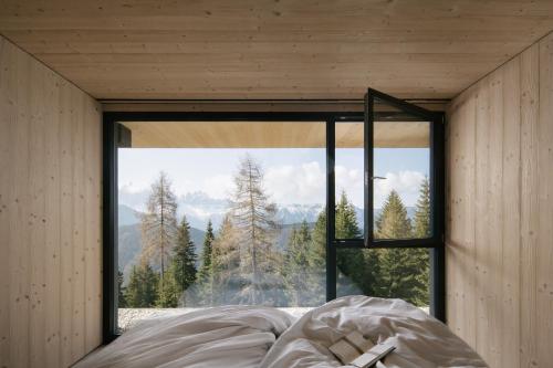 a bed in a room with a large window at anders mountain suites 7 in Brixen