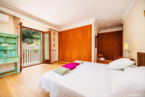 a bedroom with a white bed and a large window at Ca Nostra de Esporlas in Esporlas